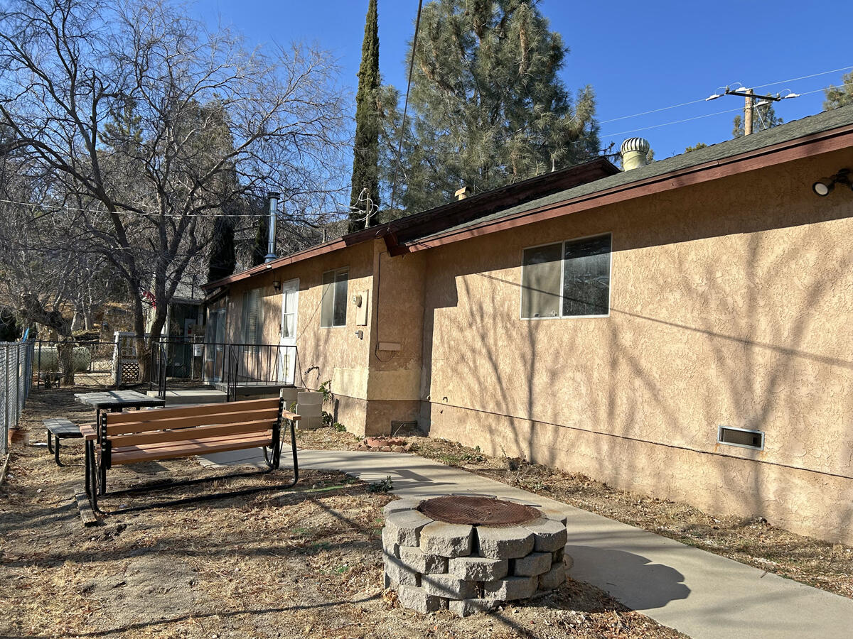 43729 Lakeview Road Lake Hughes, CA 93532 - Photo 4 of 16 a backyard of a house with wooden fence and large trees