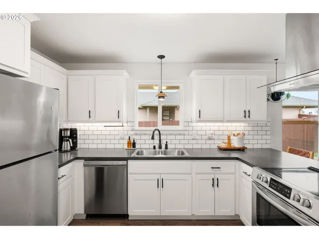 a kitchen with kitchen island granite countertop a sink stainless steel appliances and white cabinets