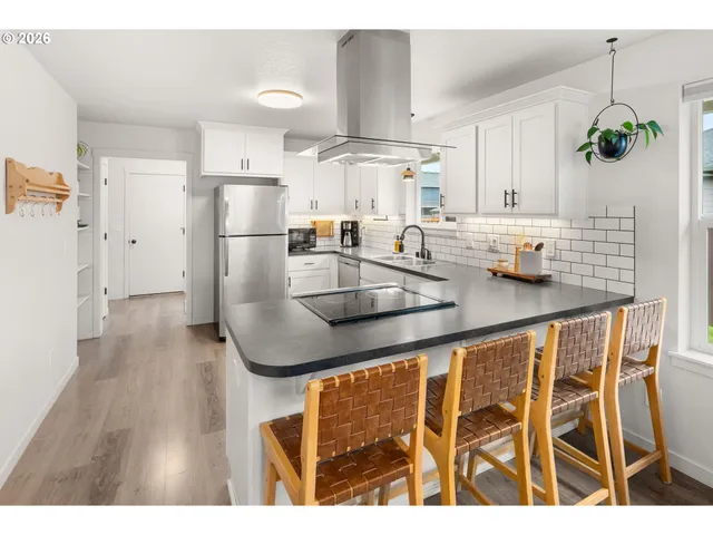 a kitchen with stainless steel appliances granite countertop a sink a refrigerator and a granite counter tops