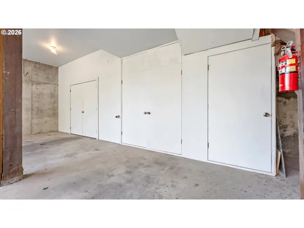 a open living room with a white wall and cabinets
