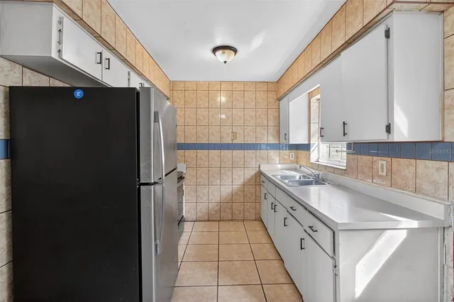 a kitchen with a sink a refrigerator and cabinets