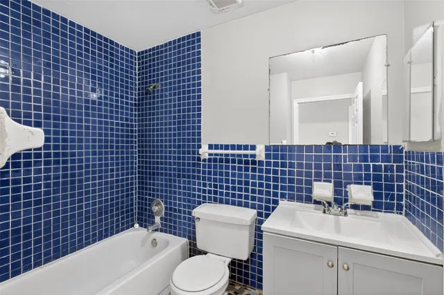 a bathroom with a blue sink a toilet and a mirror