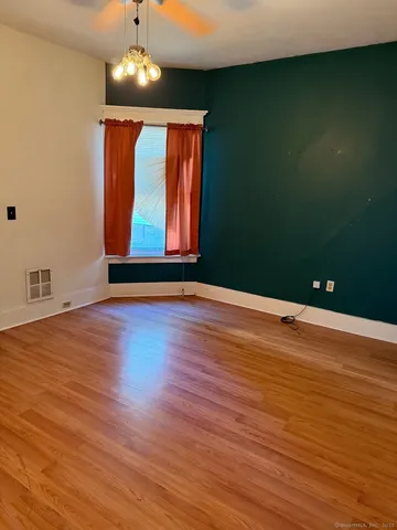 a view of room with wooden floor and fan