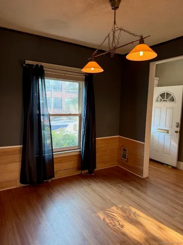 an empty room with windows and chandelier