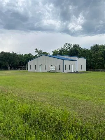 a view of a house with a big yard and large trees