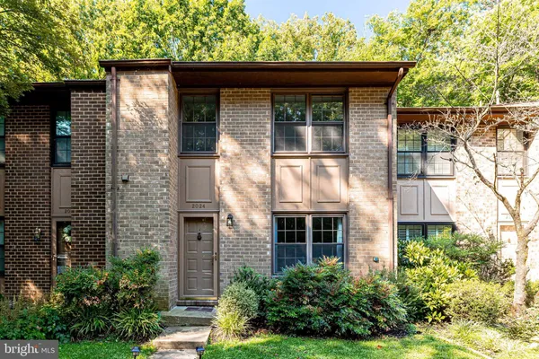 a front view of a house with plants