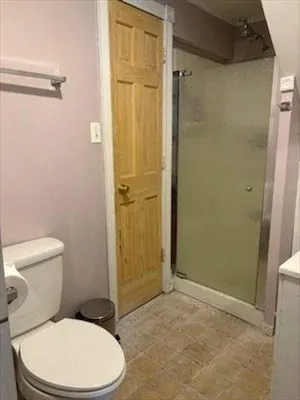 a white toilet sitting next to a shower