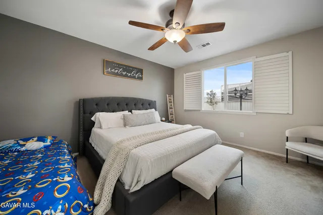 a bedroom with a bed a chandelier and a chair