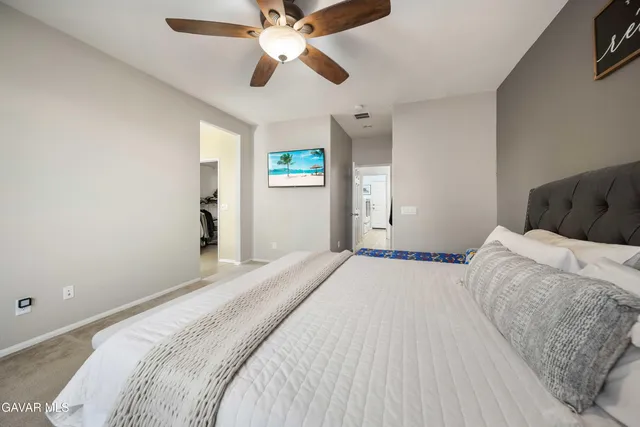 a bedroom with a large bed and a chandelier