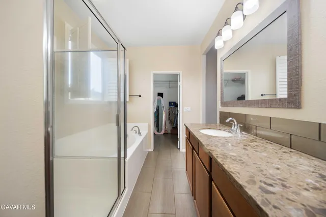 a en suite bathroom with a granite countertop sink and a mirror