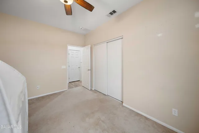 an empty room with chandelier fan