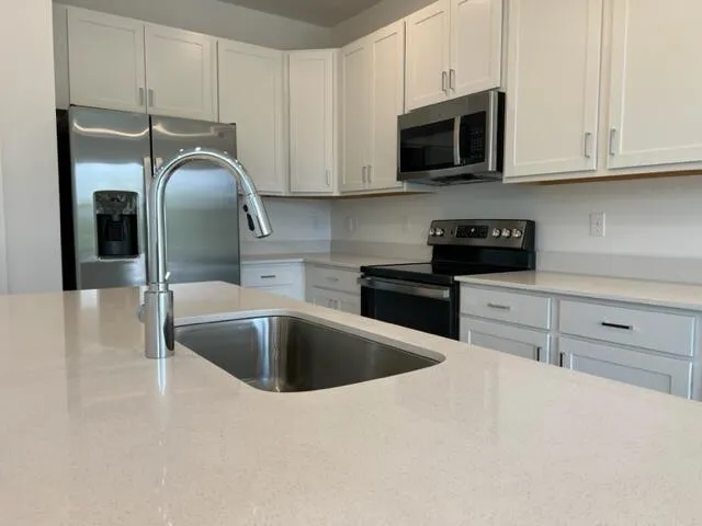 a kitchen with granite countertop a sink and a microwave