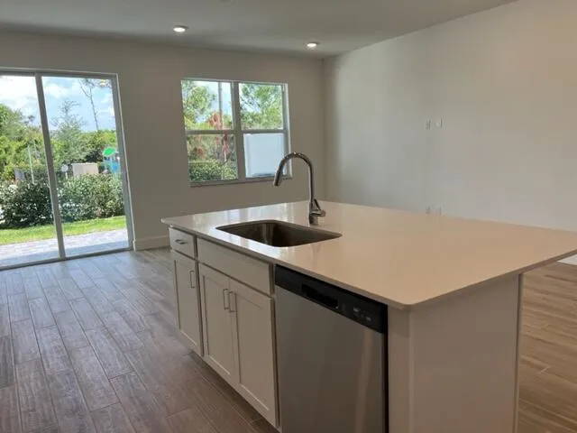 a kitchen with a sink and wooden floor