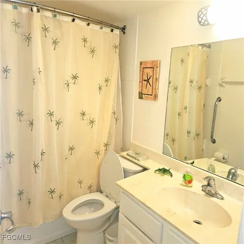 a bathroom with a sink toilet mirror and shower