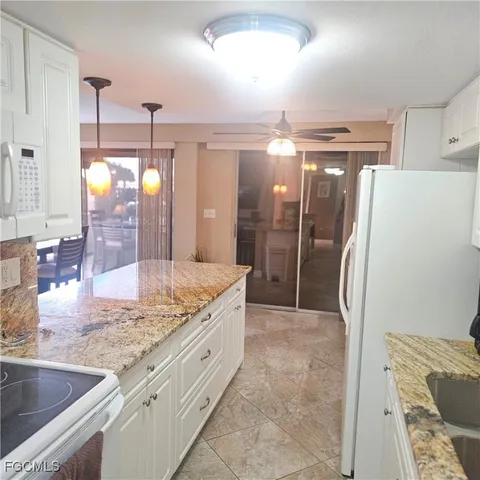 a bathroom with a granite countertop sink a toilet a mirror and shower