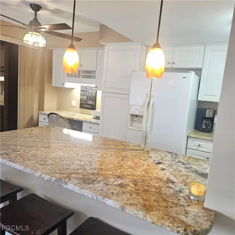 a view of a kitchen with a sink and chandelier