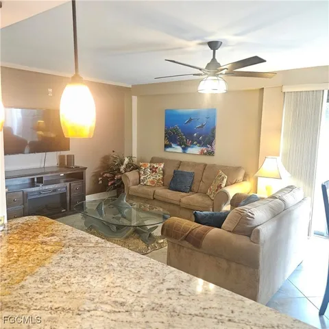 a living room with furniture a chandelier and a flat screen tv