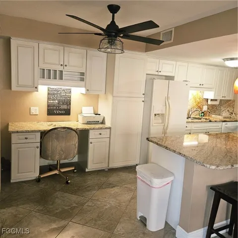 a view of a kitchen with a sink appliances and cabinets