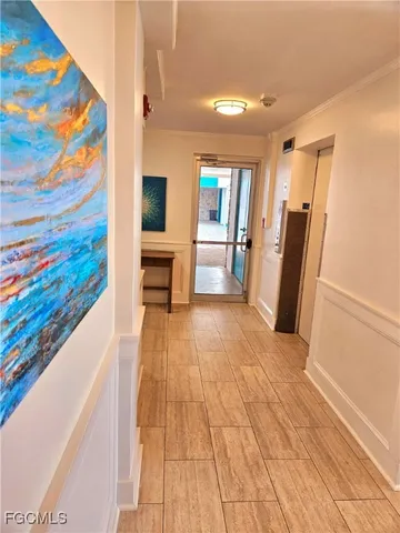 a view of a hallway with wooden floor and furniture