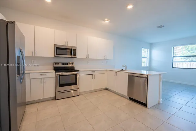 a kitchen with cabinets appliances and a window
