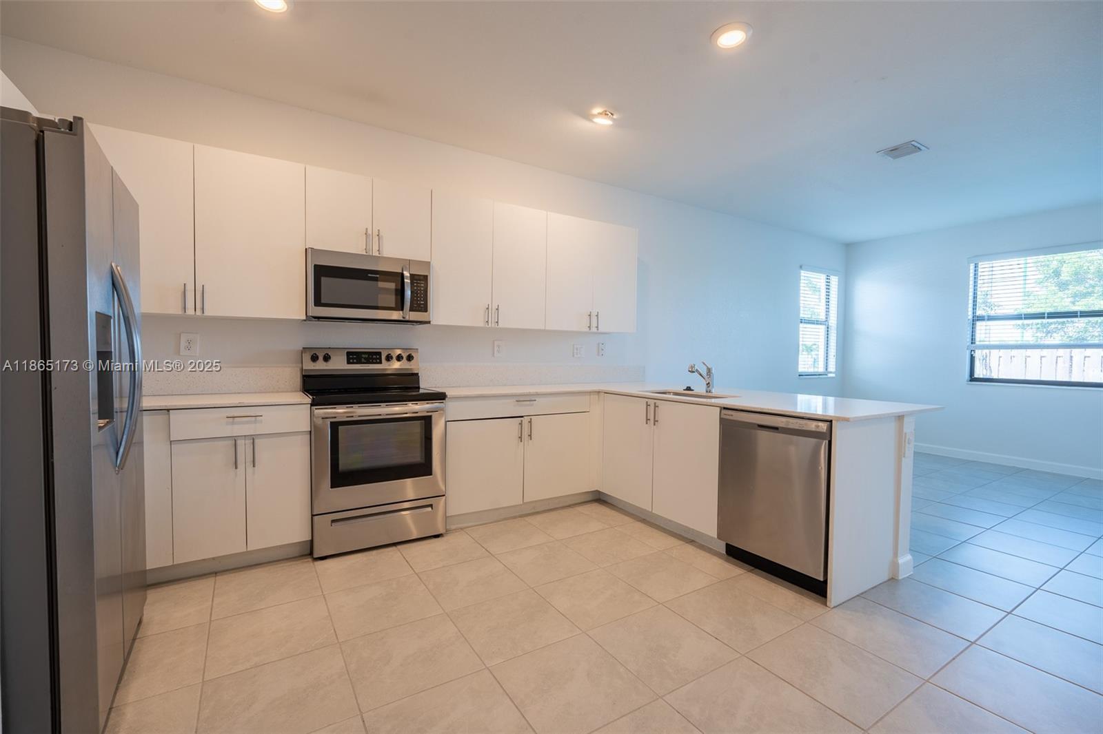 24720 Southwest 119th Place, Unit 24720 Homestead, FL 33032 - Photo 11 of 30 a kitchen with cabinets appliances and a window
