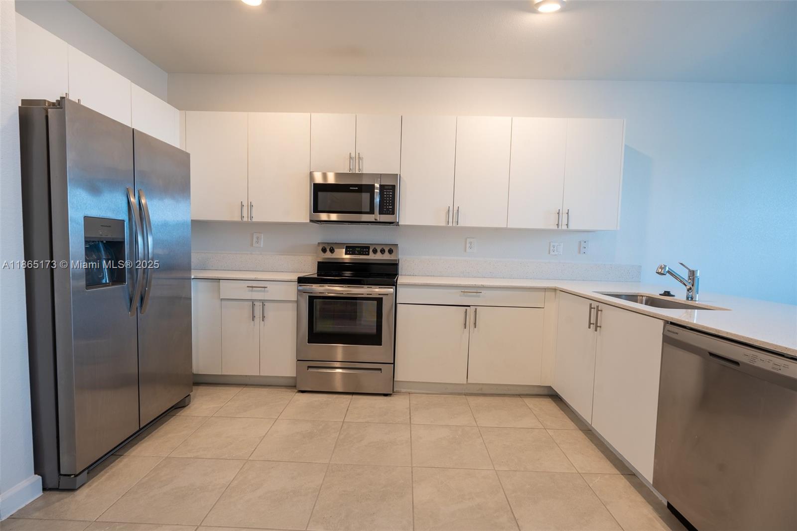 24720 Southwest 119th Place, Unit 24720 Homestead, FL 33032 - Photo 12 of 30 a kitchen with stainless steel appliances and white cabinets