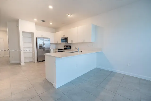 a kitchen with a sink a counter top space and stainless steel appliances