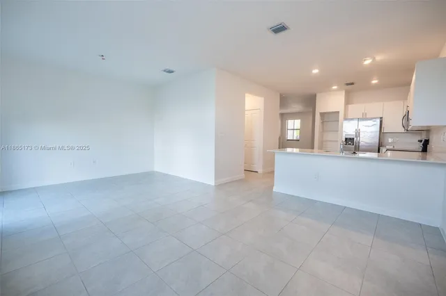 a view of a kitchen with kitchen island and a sink