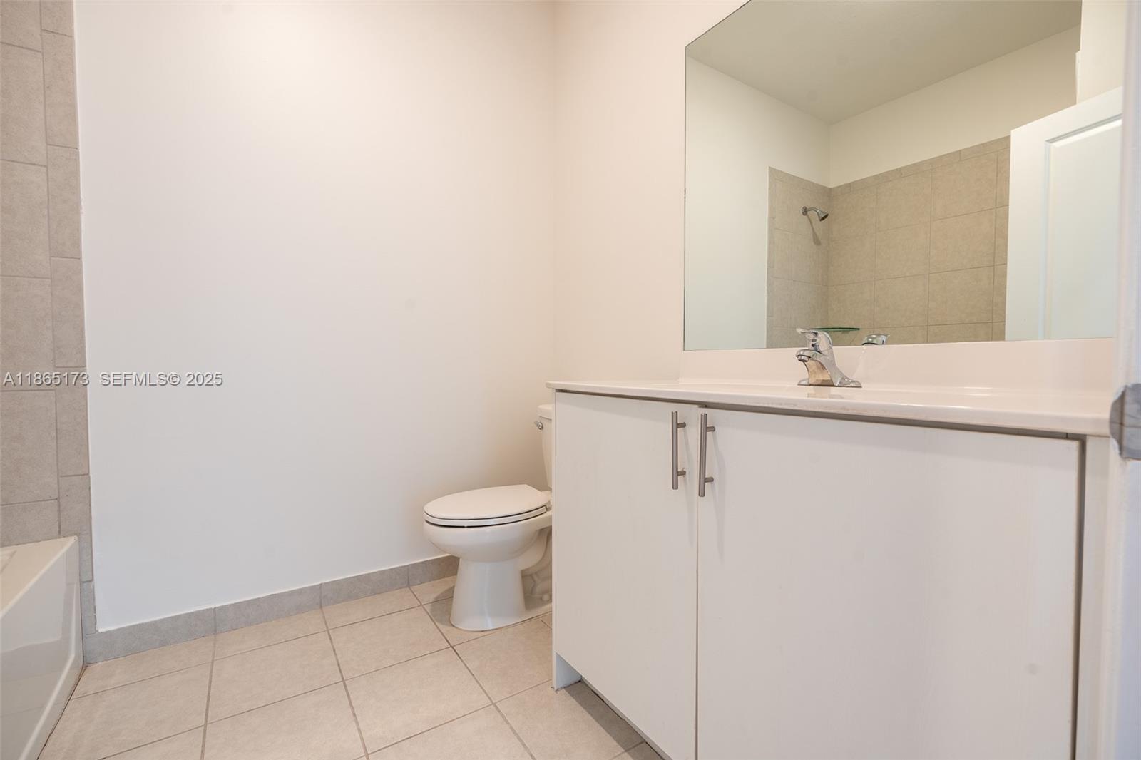 24720 Southwest 119th Place, Unit 24720 Homestead, FL 33032 - Photo 28 of 30 a white toilet sitting next to a bathroom sink