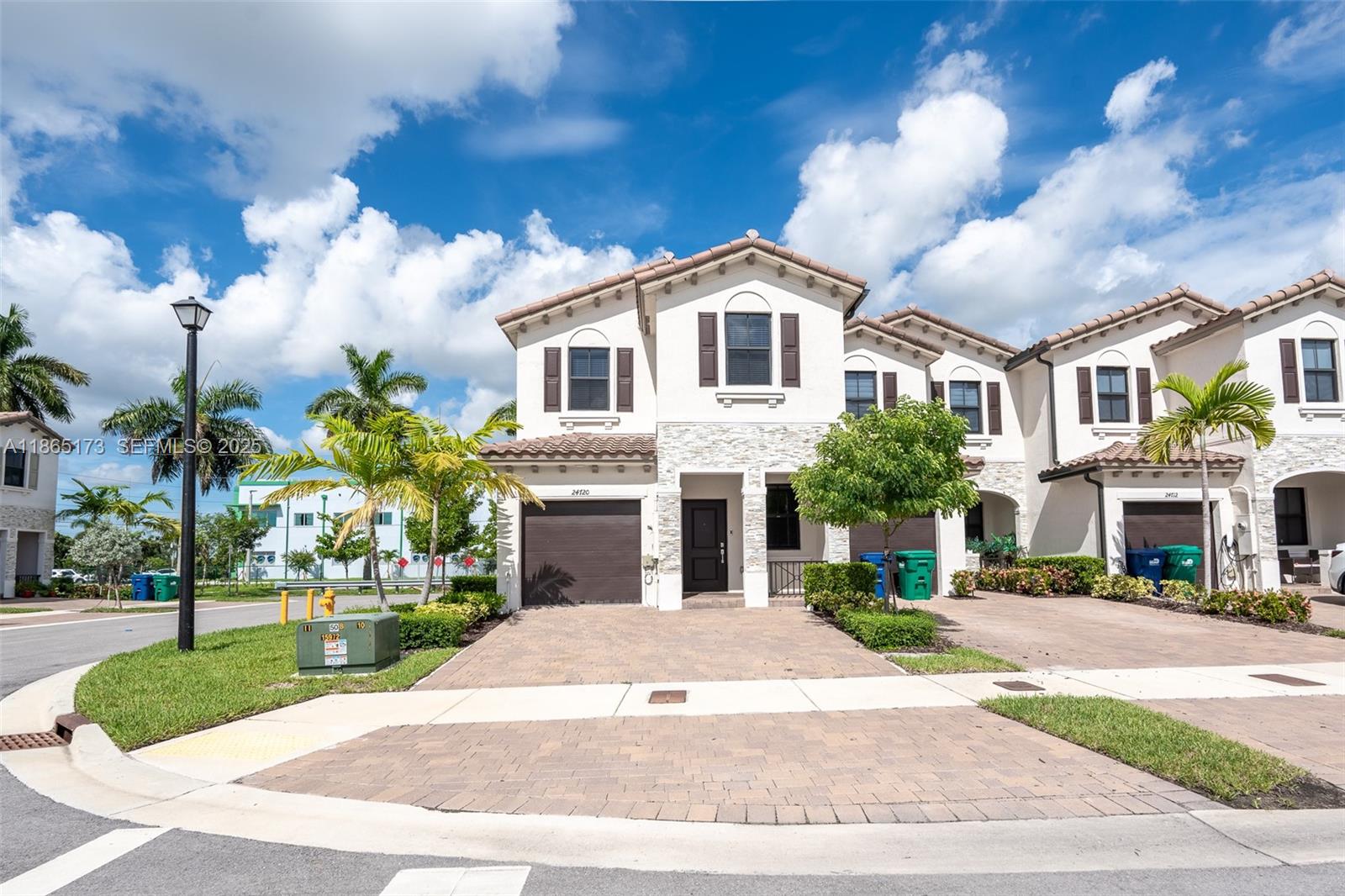 24720 Southwest 119th Place, Unit 24720 Homestead, FL 33032 - Photo 3 of 30 a view of a white house with a small yard and potted plants