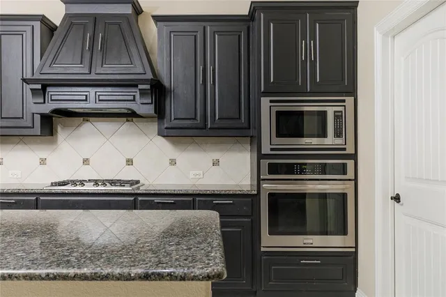 a kitchen with granite countertop a stove and a microwave
