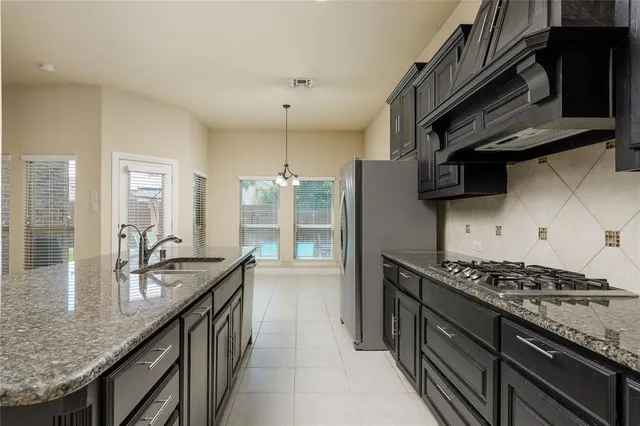 a kitchen with granite countertop a sink stove and cabinets