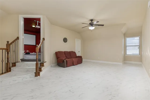 an empty room with windows and ceiling fan