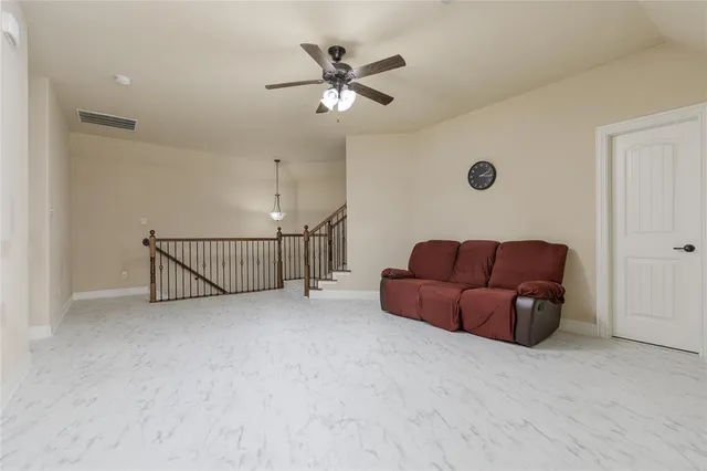 a living room with furniture and a ceiling fan