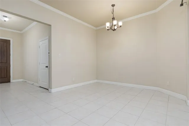 an empty room with chandelier fan