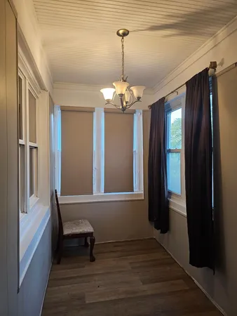 a view of a hallway with windows and chandelier