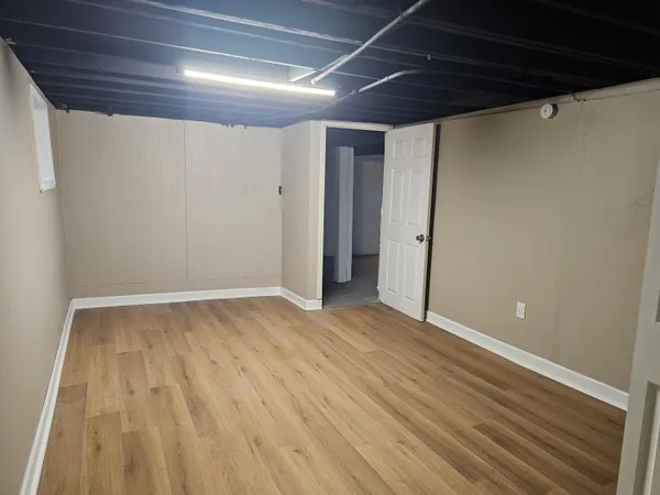 a view of an empty room with wooden floor