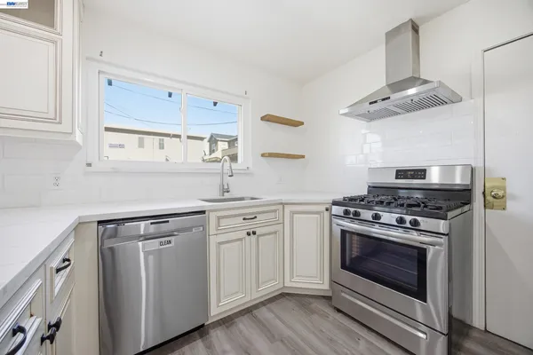 a kitchen with cabinets stainless steel appliances and wooden floor