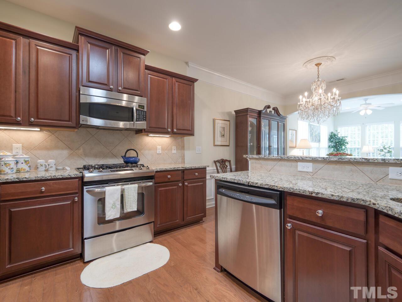 724 Eldridge Loop Cary, NC 27519 - Photo 14 of 38 a kitchen with granite countertop stainless steel appliances and wooden cabinets