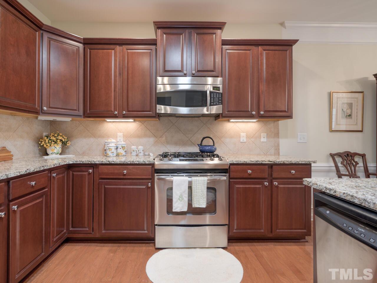 724 Eldridge Loop Cary, NC 27519 - Photo 16 of 38 a kitchen with stainless steel appliances granite countertop a sink stove and cabinets