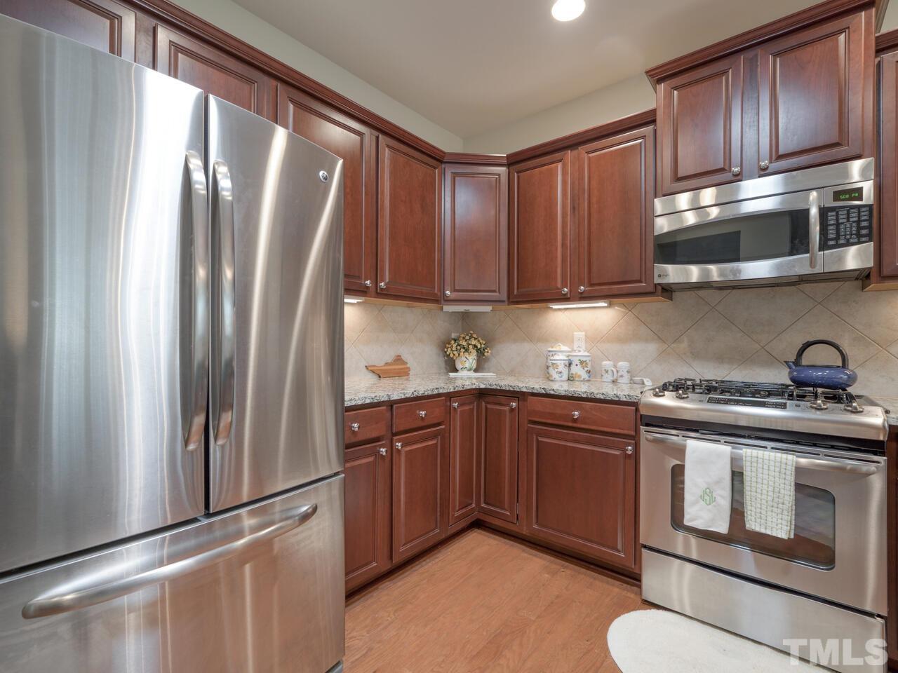 724 Eldridge Loop Cary, NC 27519 - Photo 17 of 38 a kitchen with stainless steel appliances granite countertop a refrigerator sink and stove