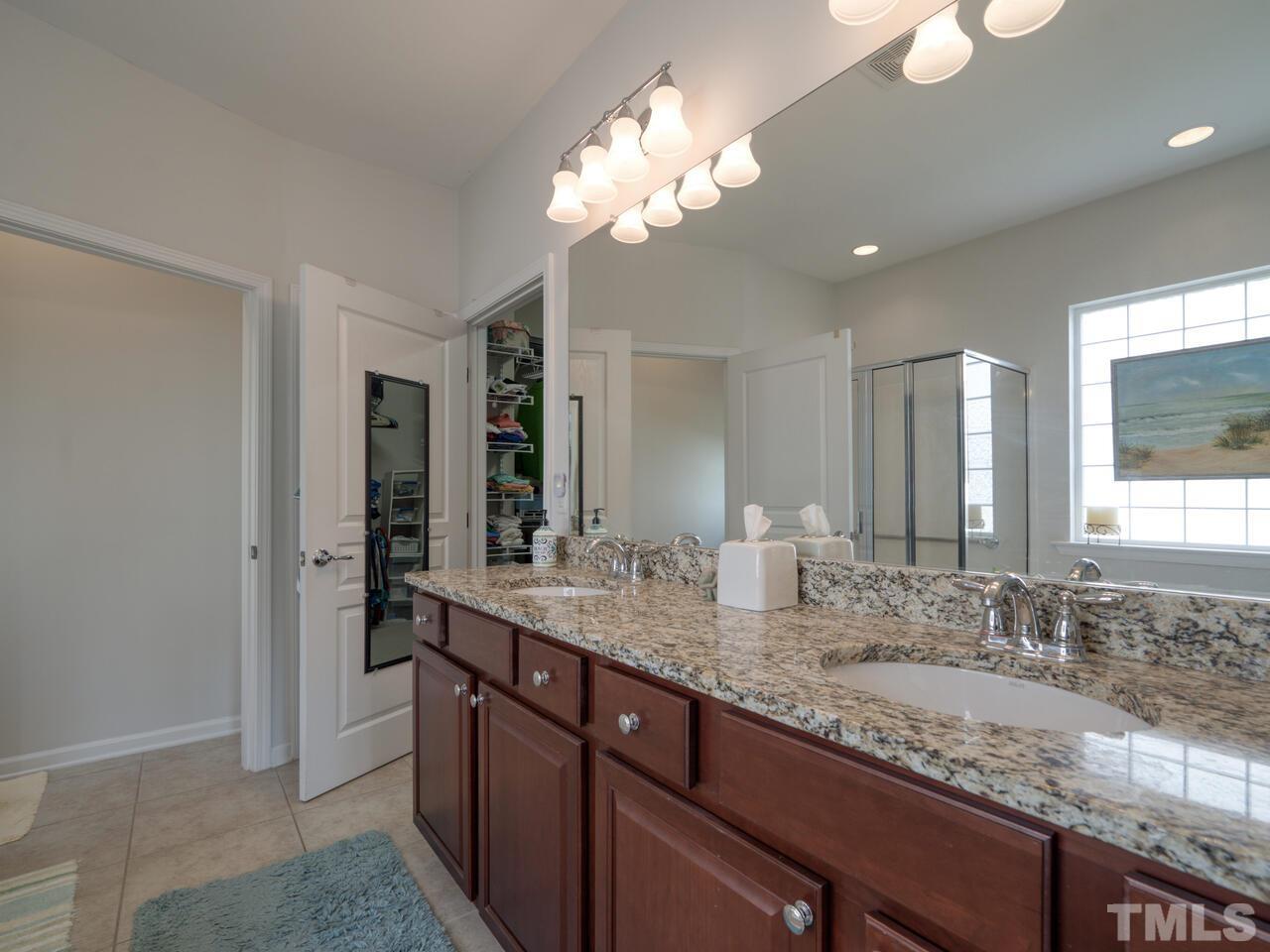 724 Eldridge Loop Cary, NC 27519 - Photo 23 of 38 a bathroom with a granite countertop double vanity sink and a mirror