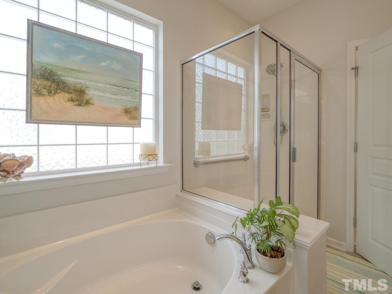 724 Eldridge Loop Cary, NC 27519 - Photo 24 of 38 a bathroom with a bathtub and a shower