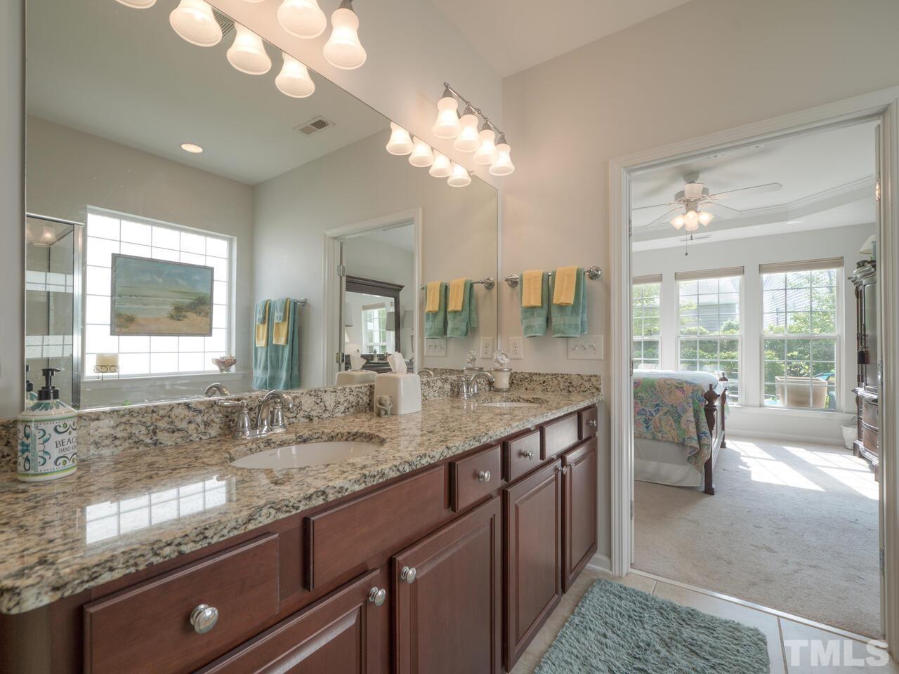 724 Eldridge Loop Cary, NC 27519 - Photo 25 of 38 a bathroom with a granite countertop sink a large mirror and a window