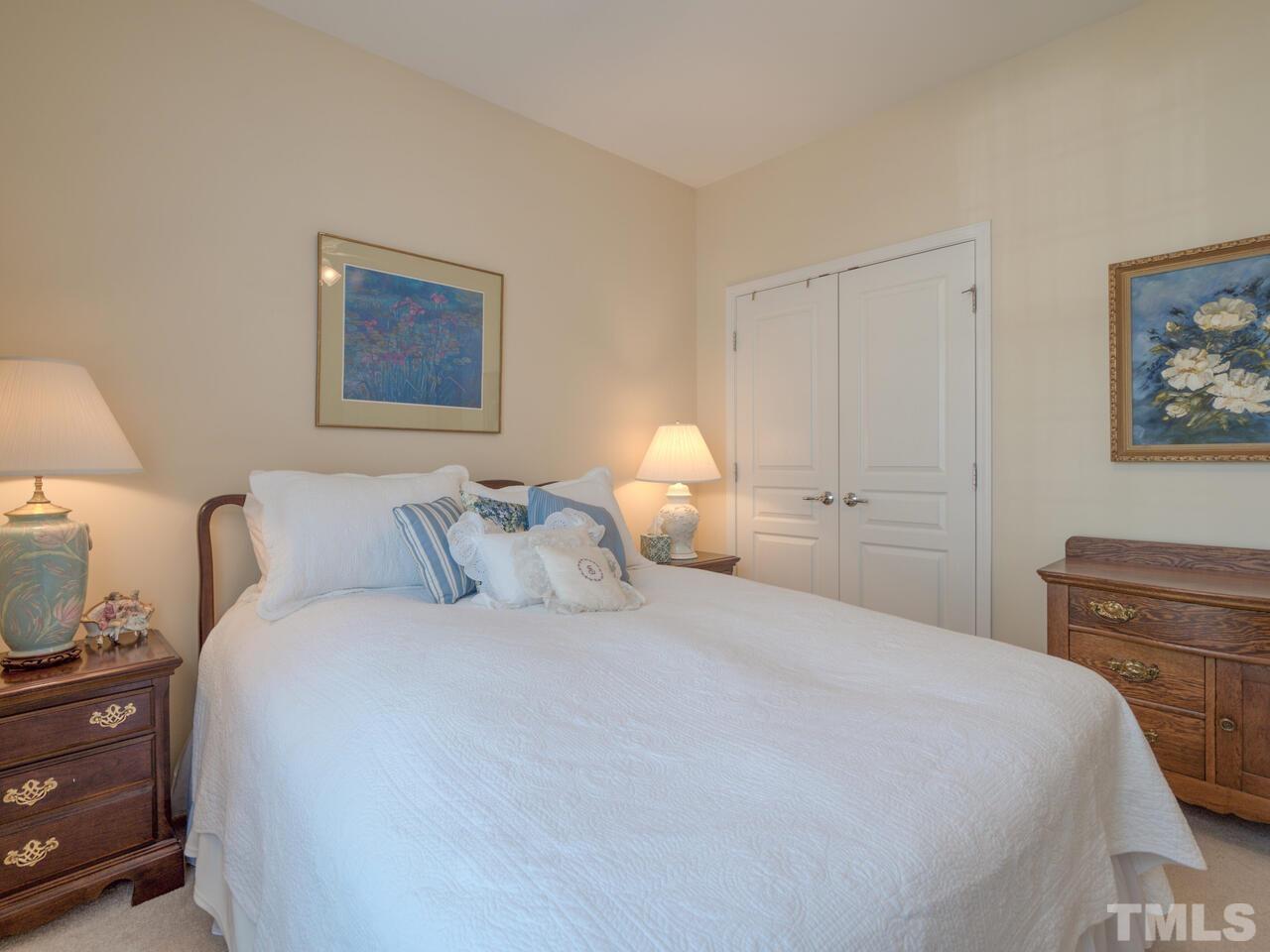 724 Eldridge Loop Cary, NC 27519 - Photo 30 of 38 a bedroom with a bed and a lamp on dresser