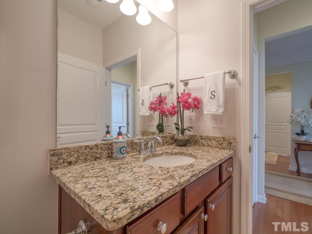 724 Eldridge Loop Cary, NC 27519 - Photo 32 of 38 a bathroom with a granite countertop sink and a mirror