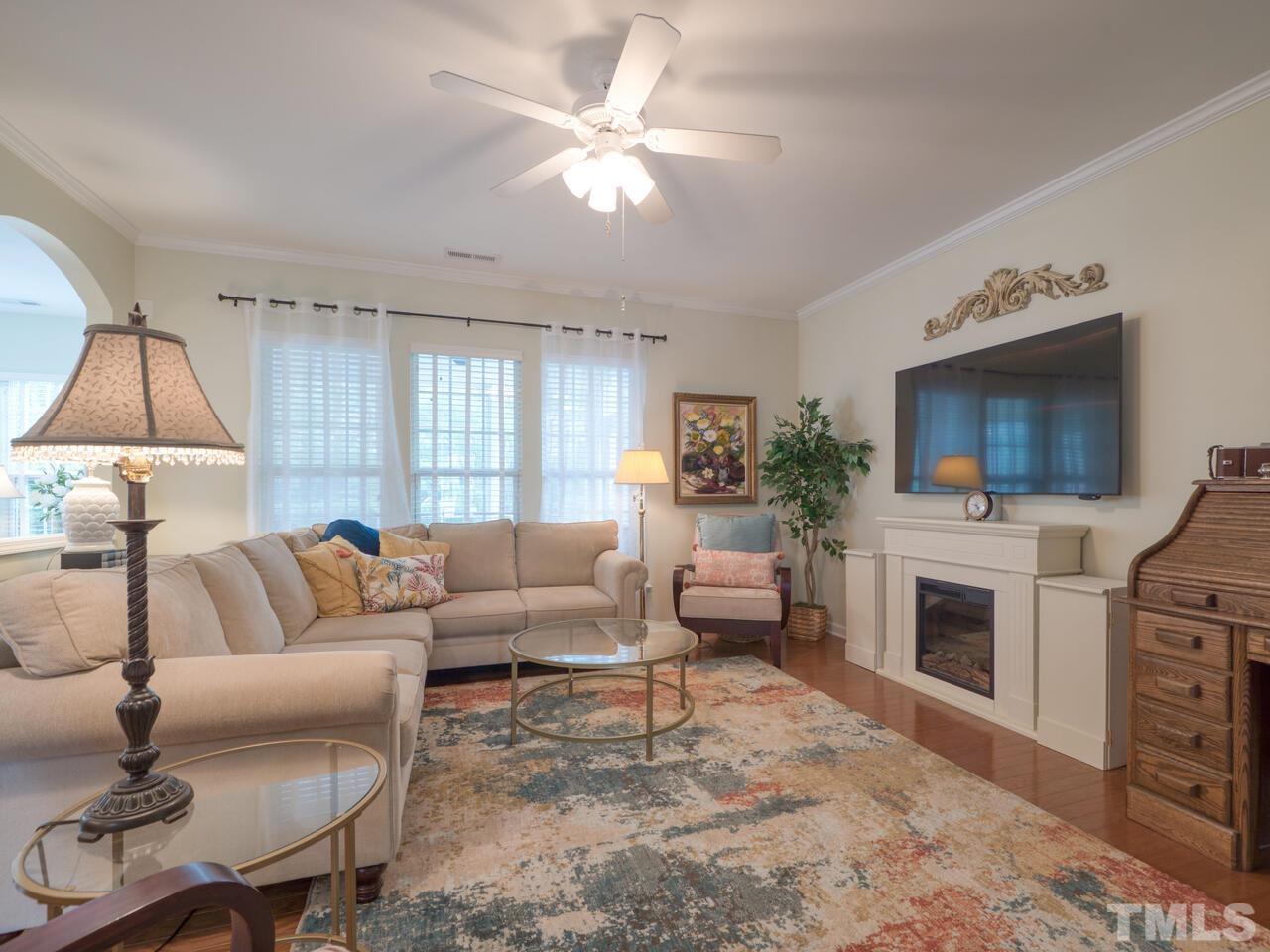 724 Eldridge Loop Cary, NC 27519 - Photo 6 of 38 a living room with furniture a fireplace and a flat screen tv