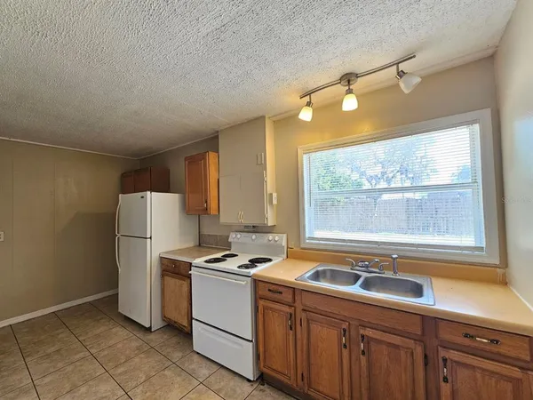 a kitchen with a refrigerator a sink and cabinets
