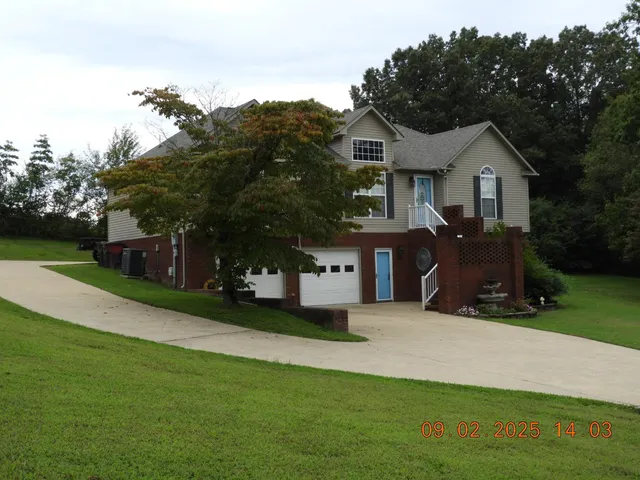 a front view of a house with a garden and trees