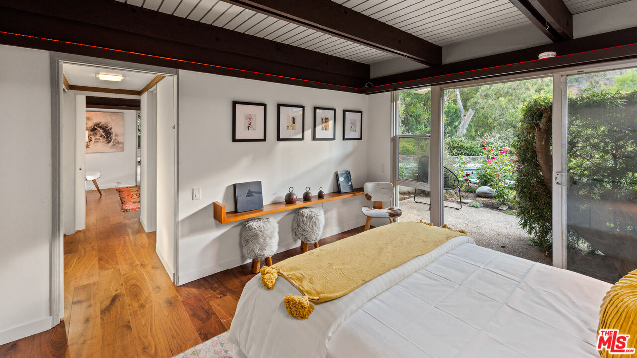 1030 Rivas Canyon Road Pacific Palisades, CA 90272 - Photo 20 of 42 a bedroom with furniture and a large window